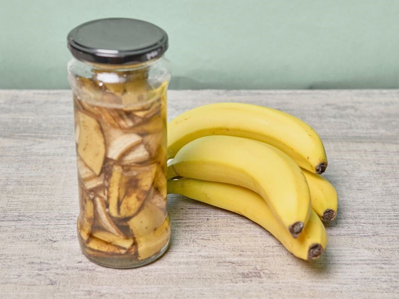 A jar filled with banana peel cuts and water